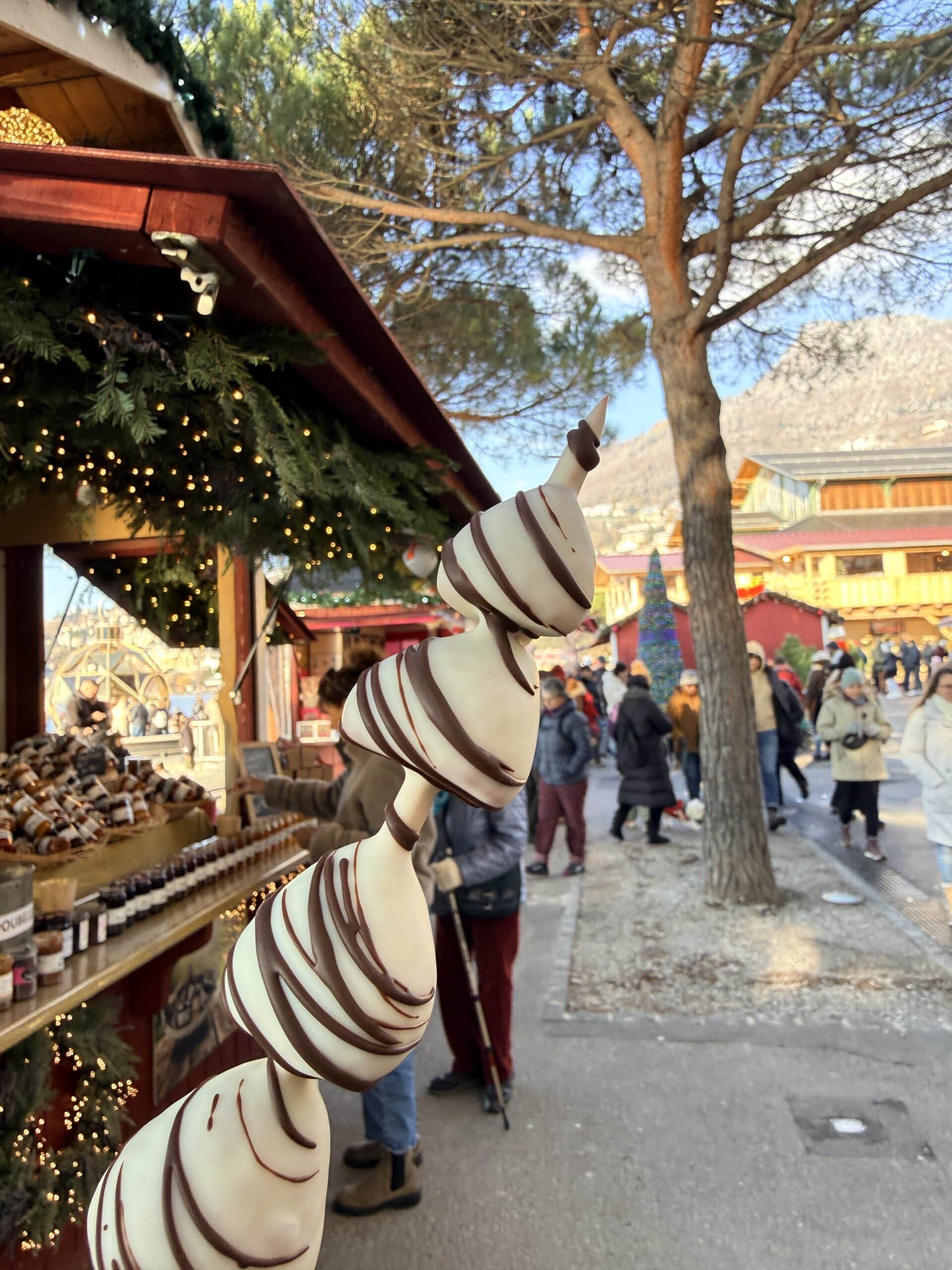 Une brochette de fruits avec les chalets de Montreux Riviera Noël en arrière plan